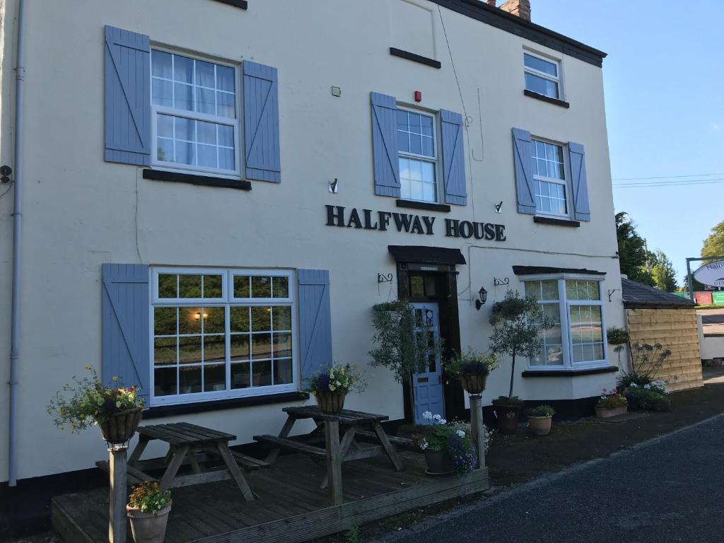 a white and blue building with a sign on the front of it at Halfway House in Great Malvern
