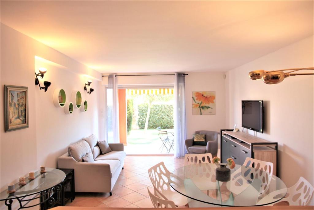 een woonkamer met een bank en een tafel bij Les Soleiades in La Londe-les-Maures