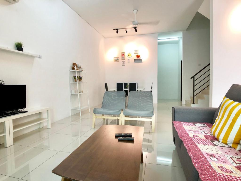 een woonkamer met een bank en een tafel bij Kampar Sakura 3 Landed in Kampar