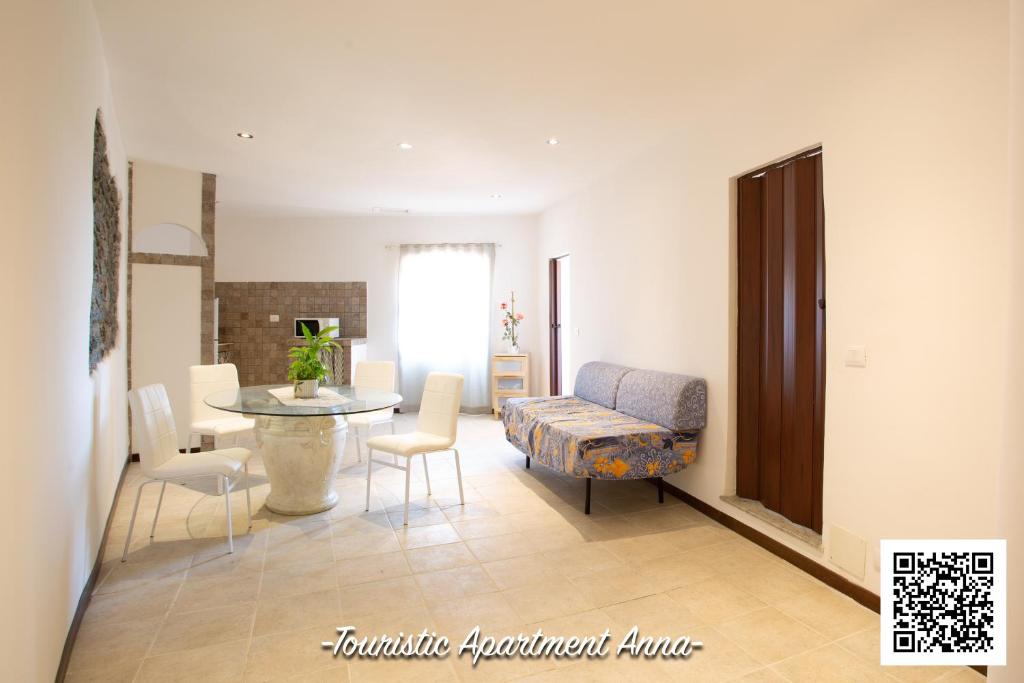 uma sala de estar com um sofá, uma mesa e cadeiras em Tourist Apartment Anna em Bracciano