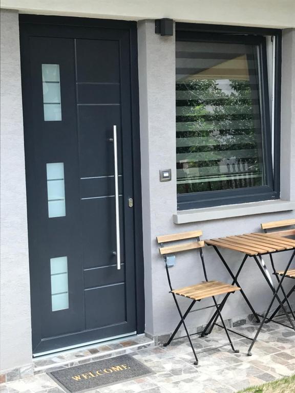 a black door with two chairs next to a table at M+V apartment in Alexandroupoli