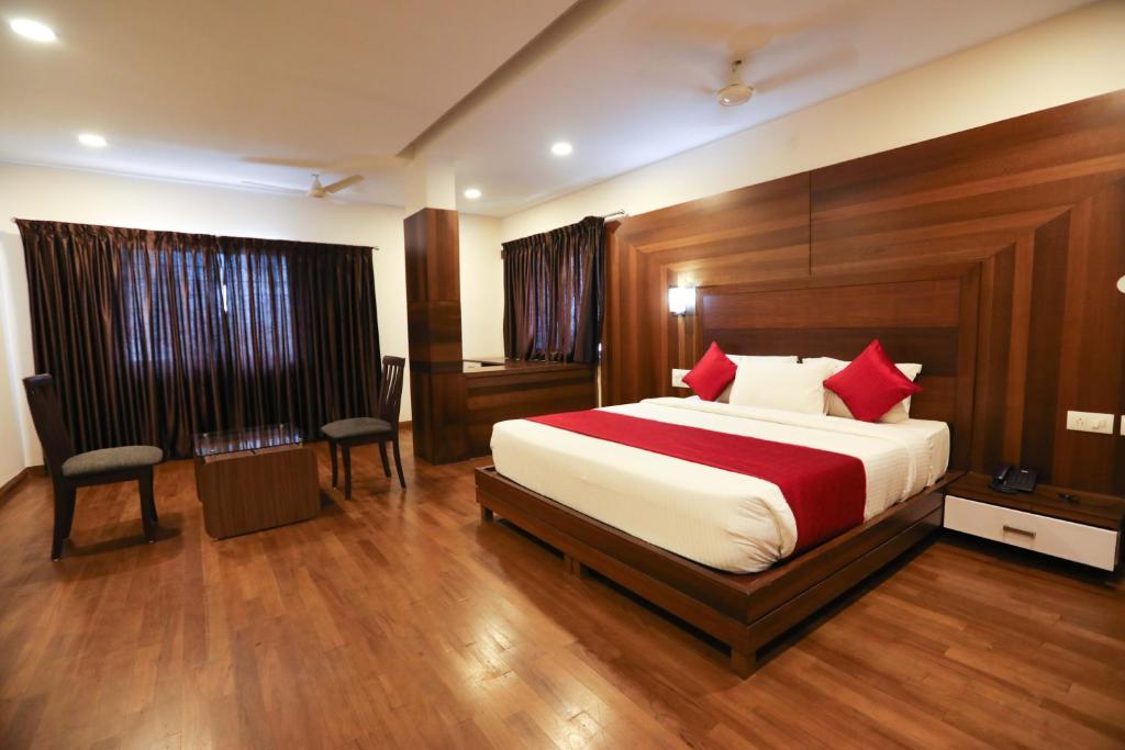 Un dormitorio con una cama grande con almohadas rojas. en Traders Hotel - Kankanady, Mangalore, en Mangalore