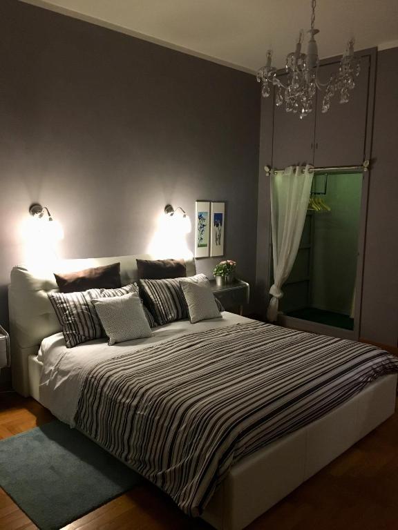 a bedroom with a large bed with a chandelier at a casa di Narciso e Margherita in Foligno