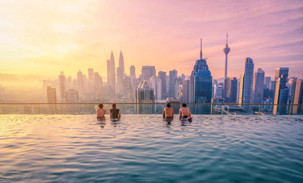 a group of people in a infinity pool with a city skyline at Regalia Skypool KLCC in Kuala Lumpur