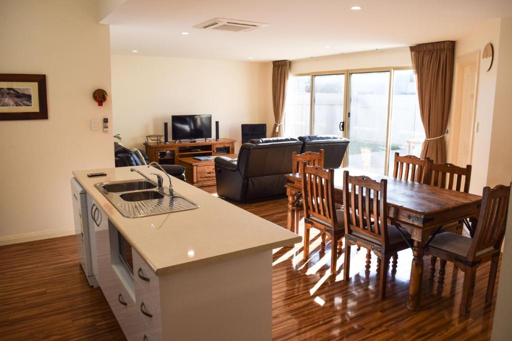 艾略特港的住宿－艾略特港長灘度假屋，厨房以及带桌椅的起居室。