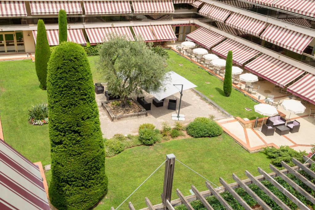 una vista aérea de un jardín con árboles y bancos en The Originals Boutique, Hôtel Les Strélitzias, en Juan-les-Pins