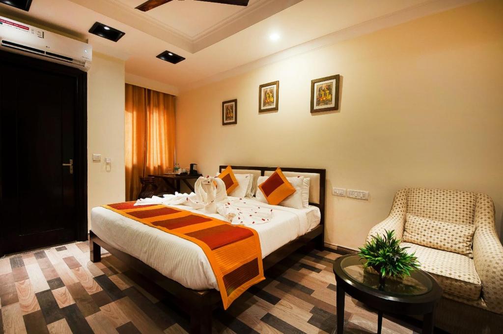 a hotel room with a bed and a chair at The Oakland Plaza by Orion Hotels in New Delhi