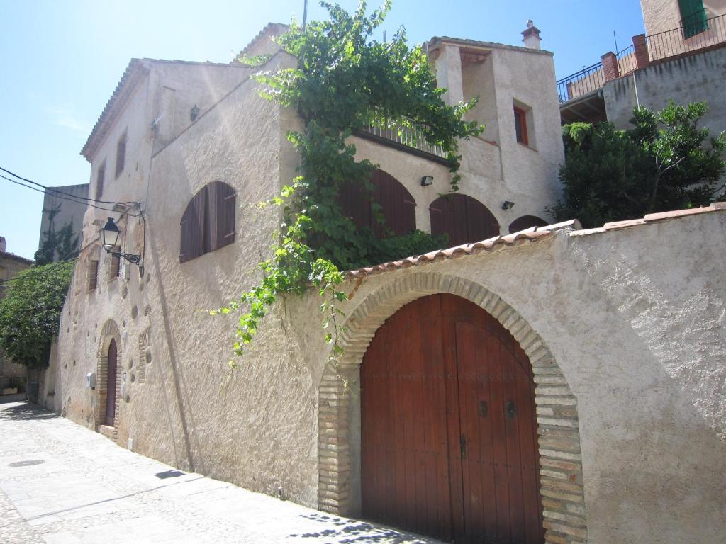 um antigo edifício de pedra com uma grande porta de madeira em Cal Alemany em Torroja