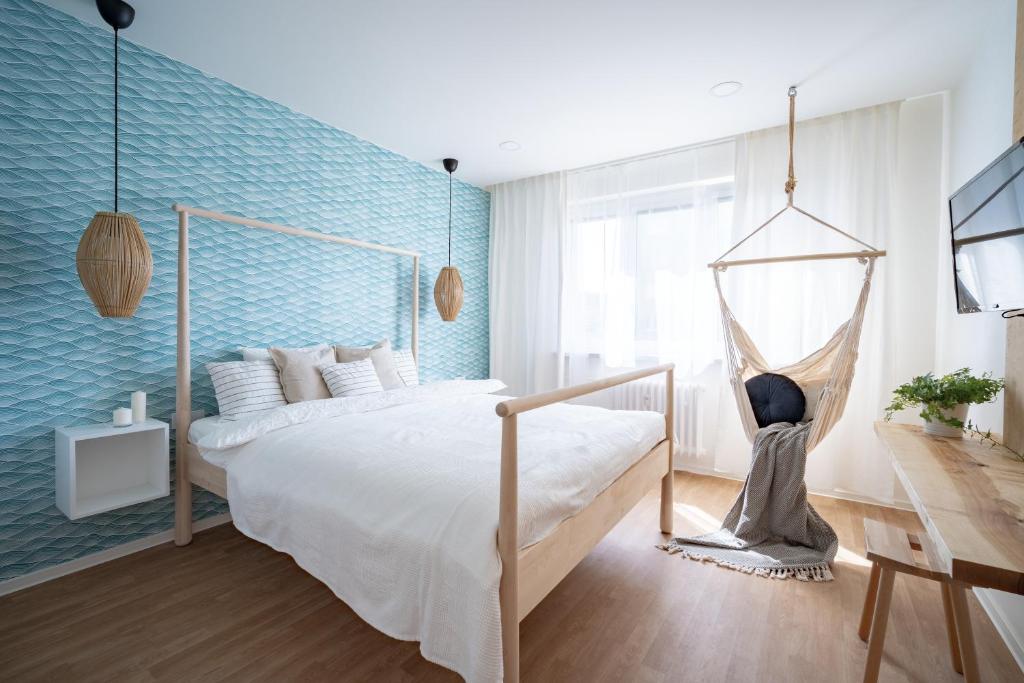 Meet Mendel Boutique Apartments #5 by Goodnite cz - Expo في برنو: غرفة نوم بسرير وجدار ازرق