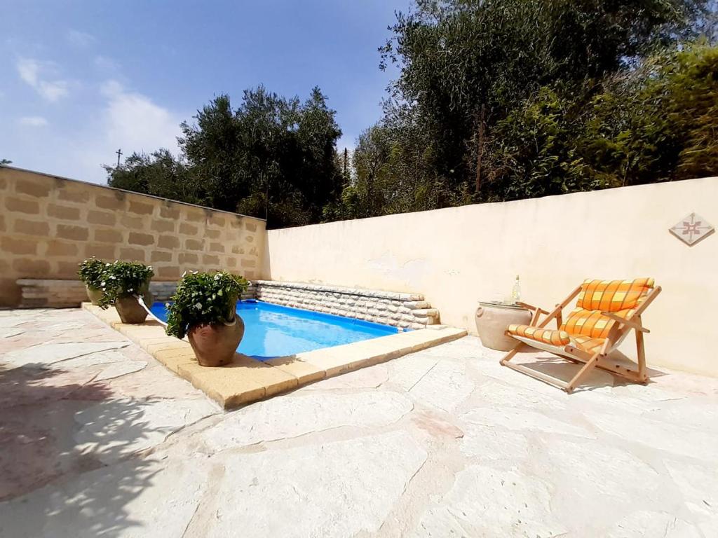 eine Terrasse mit einem Stuhl und einem Pool in der Unterkunft Appartamento Via Vulcano in Trapani