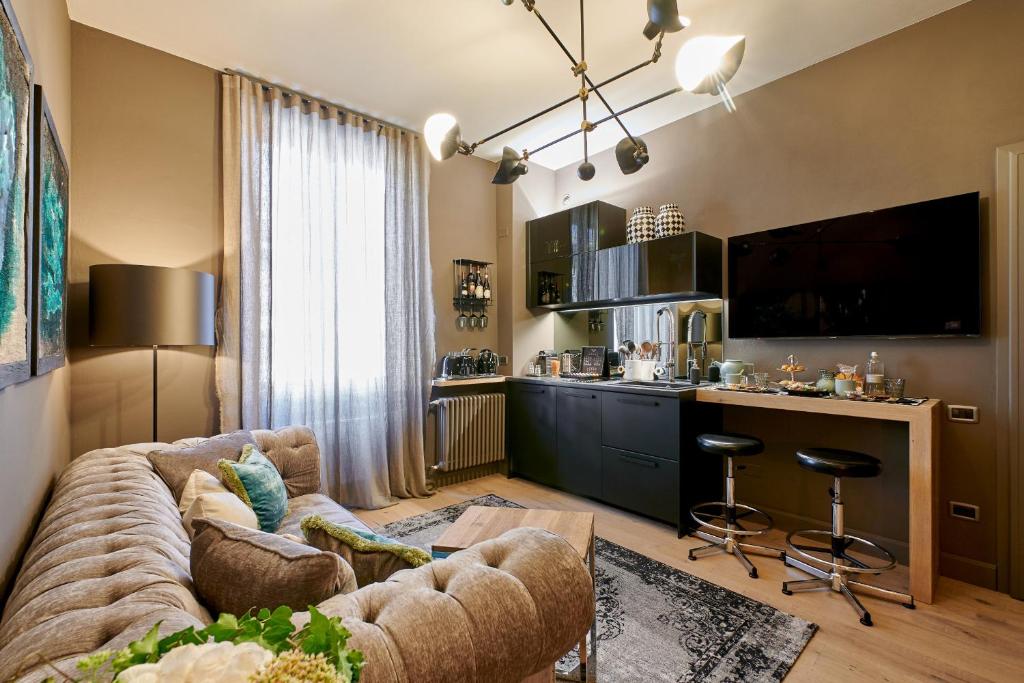 Il comprend un salon avec un grand canapé et une cuisine. dans l'établissement My Home For You - Tasso Style Apartment, à Bergame