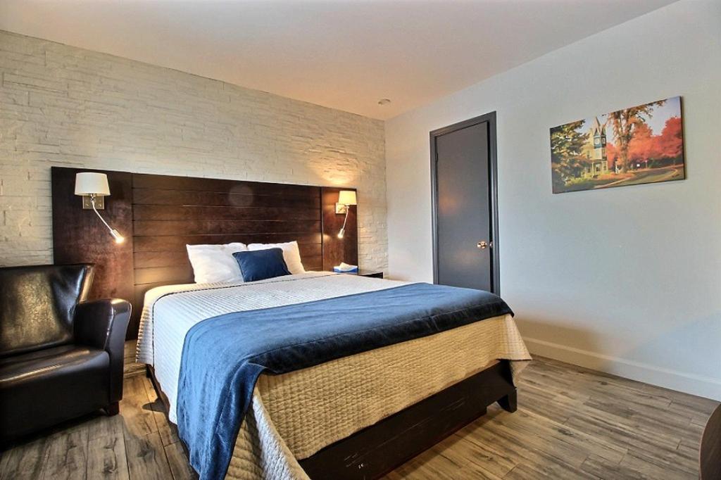 Habitación de hotel con cama y silla en Hotel Motel Le Quiet en Lac-Mégantic