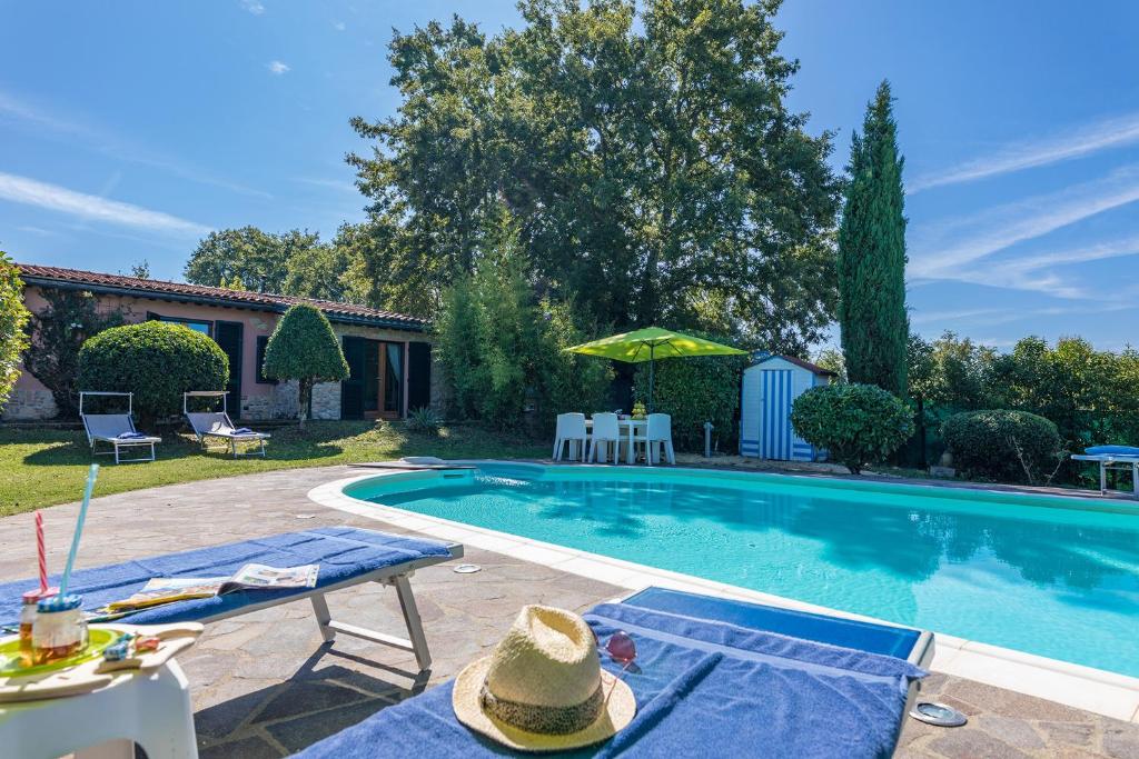 una piscina con 2 tumbonas y una mesa en Villa Edera, en Monticiano