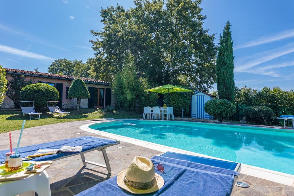 einen Pool mit 2 Liegestühlen und einem Tisch in der Unterkunft Villa Edera in Monticiano