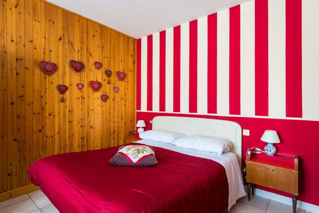 una camera da letto con parete a righe rosse e bianche di Locanda Farinati ad Abetone