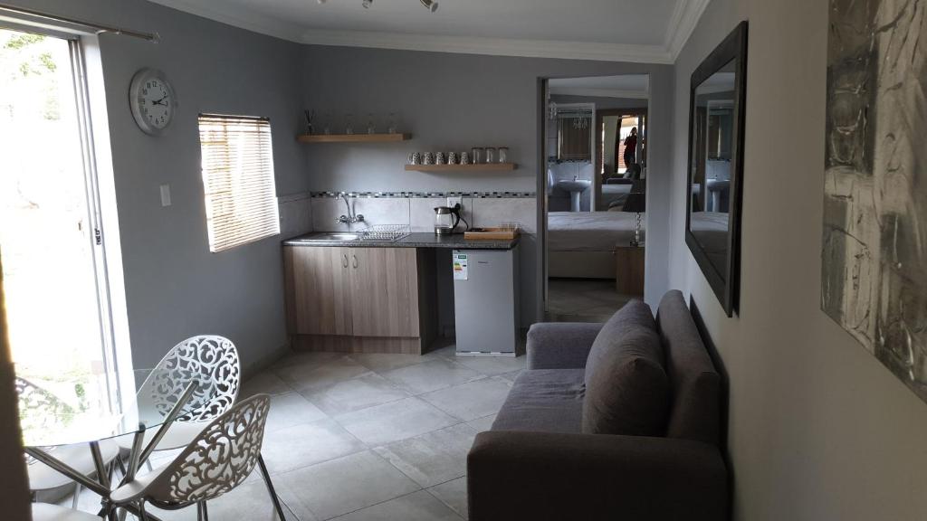 un soggiorno con divano e una cucina di Elephant Bush Guest Cottage ad Alberton