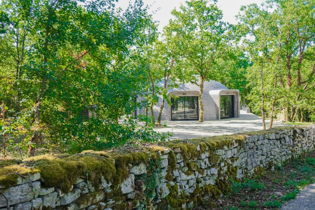 una pared de piedra frente a un edificio en GAME OF DOME en Chartrier-Ferrière