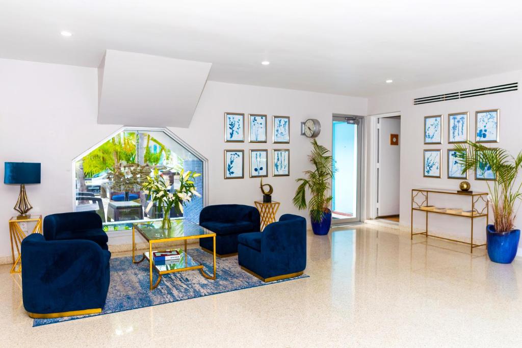 sala de estar con 2 sillas azules y mesa en Aqua Hotel & Suites en Miami Beach