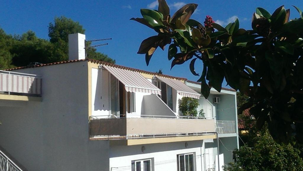 a white building with a balcony on the side of it at Apartmani Carević in Baška Voda