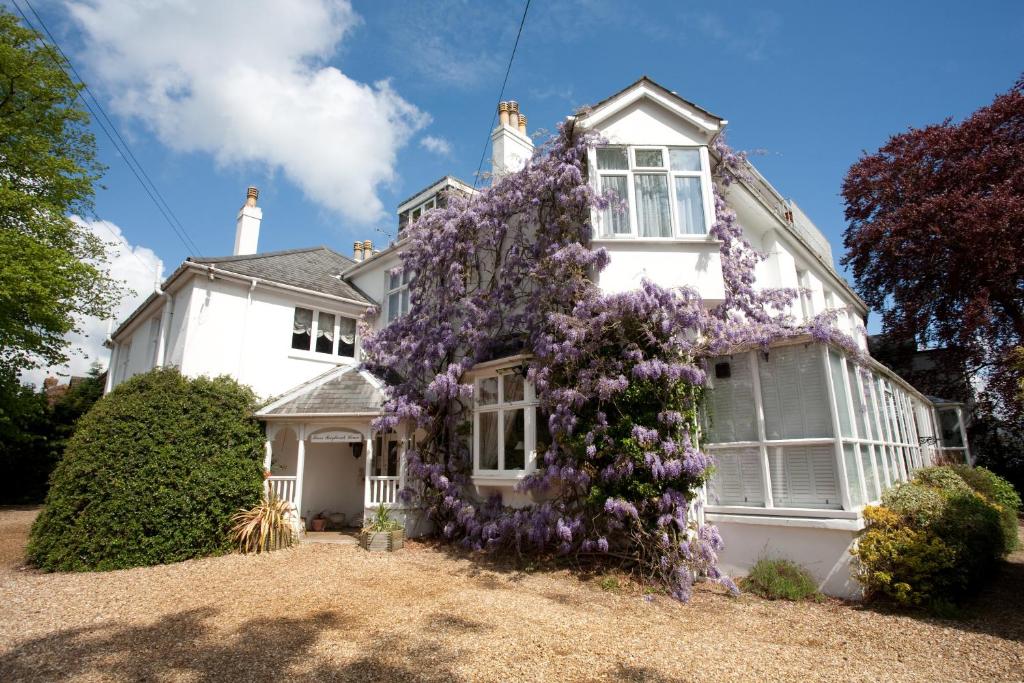 Una casa blanca con una corona en la parte delantera. en Fines Bayliwick Hotel, en Bracknell