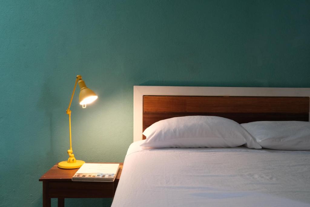 a bedroom with a bed and a lamp on a table at Casa Tunido in Santa Marta