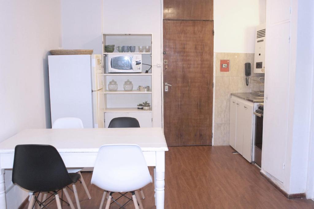 a kitchen with a white table and chairs and a refrigerator at Depa Patio Olmos in Córdoba