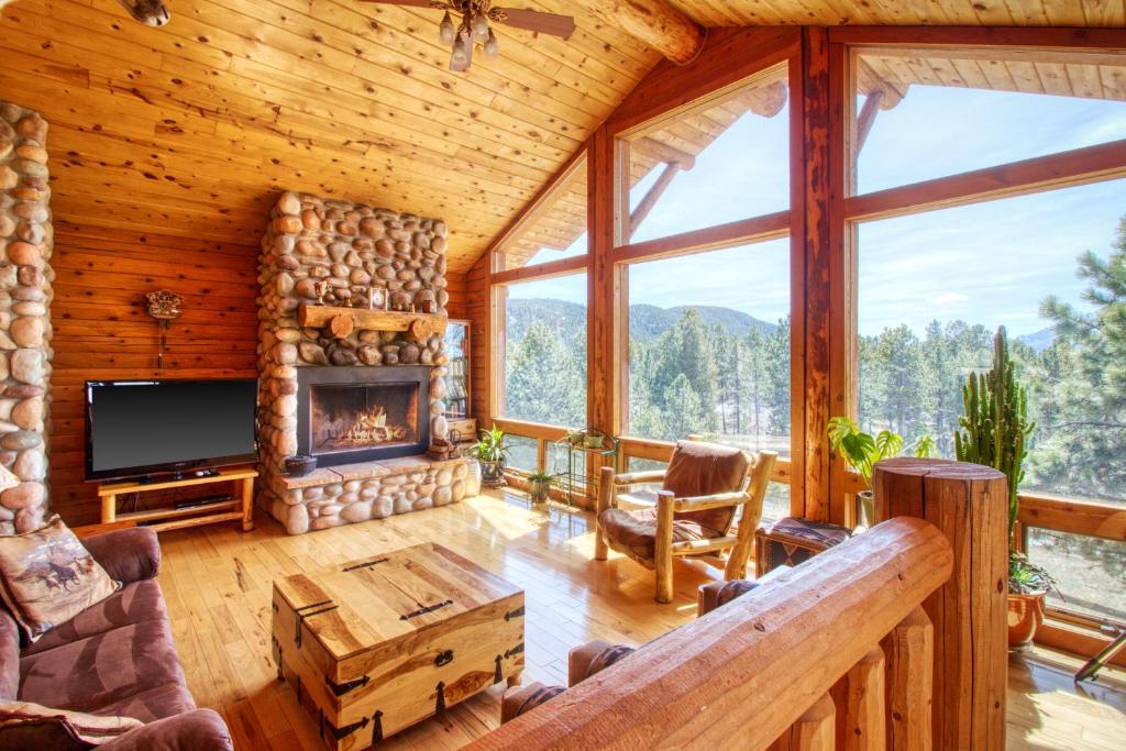 Cabaña de madera con sala de estar con chimenea en Mills Ranch en Woodland Park