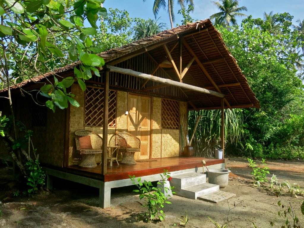 Cabaña pequeña con banco en un jardín en Mutiara Beach Resort, en Berakit
