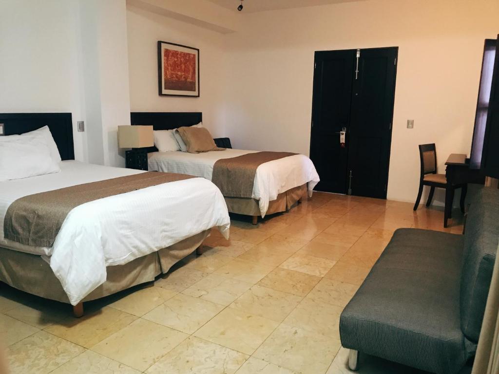 une chambre d'hôtel avec deux lits et un canapé dans l'établissement Hotel Casa las Mercedes, à Oaxaca