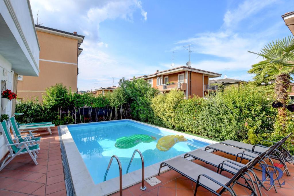 a swimming pool with chairs next to a house at DesenzanoLoft Casa Annamaria in Desenzano del Garda