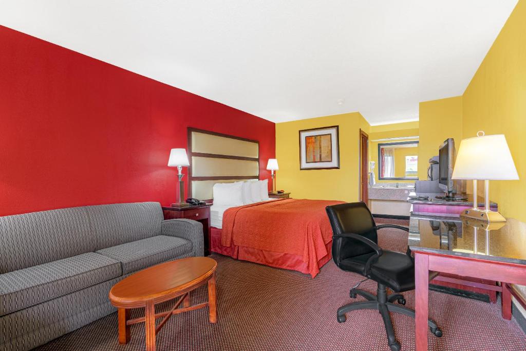 a hotel room with a bed and a couch at America's Best Value Inn-Milledgeville in Milledgeville