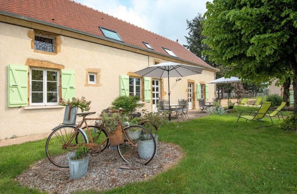 ein Fahrrad, das vor einem Haus mit einem Regenschirm geparkt ist in der Unterkunft Gîte Domaine de la Guinchère in LʼHôpital-le-Mercier