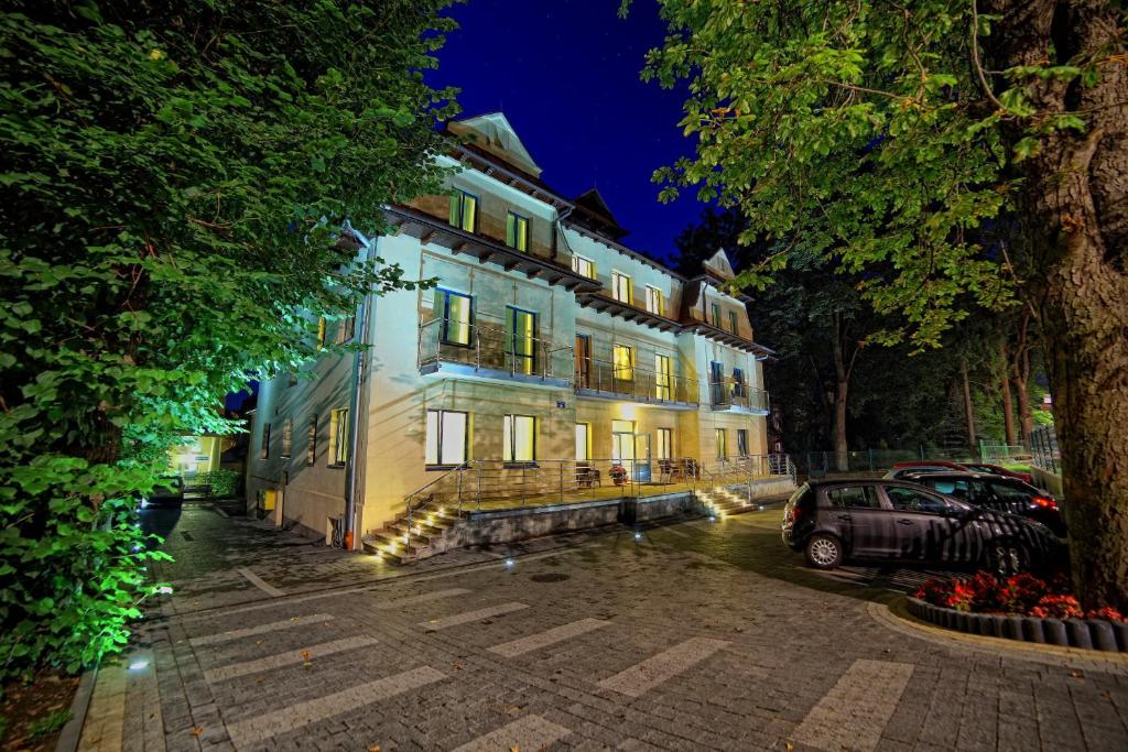 a large building with a car parked in front of it at Parkowy Dworek in Rabka-Zdrój