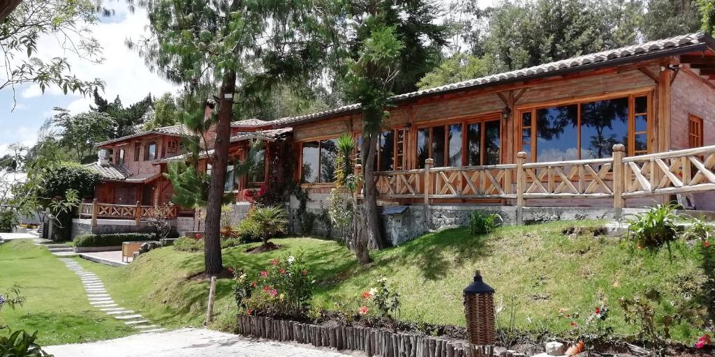 une maison sur une colline herbeuse avec un jardin dans l'établissement La Casa del colibri ecuador, à Quito