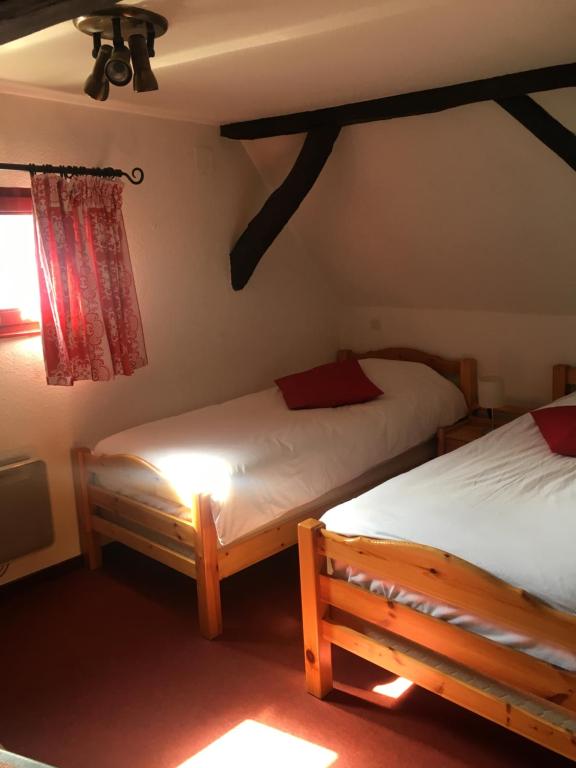1 dormitorio con 2 camas y ventana en Auberge du Tisserand en Gommersdorf