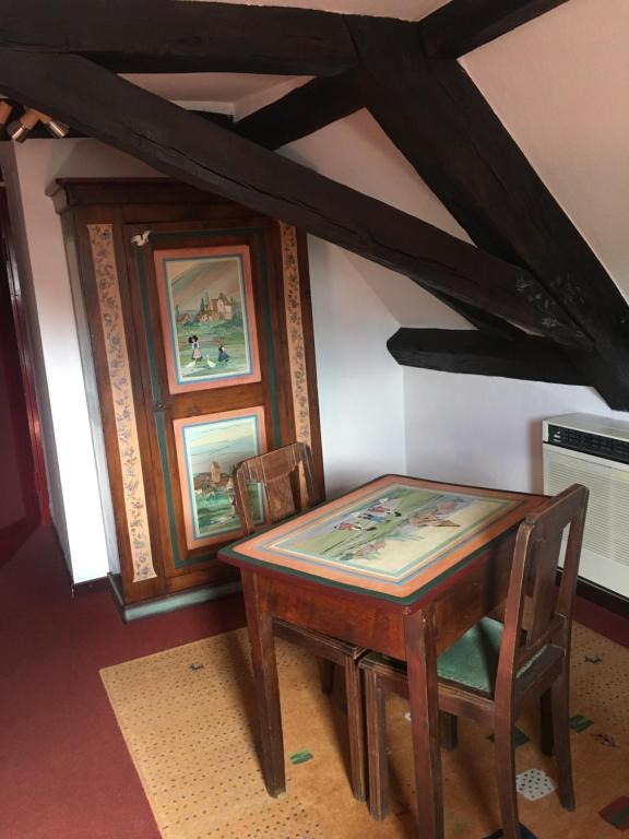 a wooden table and chairs in a room at Auberge du Tisserand in Gommersdorf