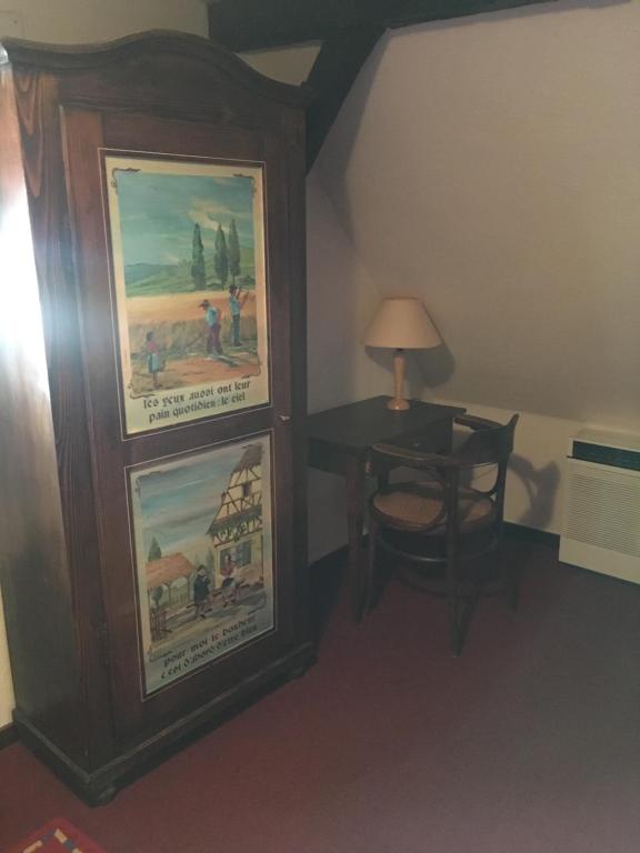 a room with a desk and a table with a lamp at Auberge du Tisserand in Gommersdorf