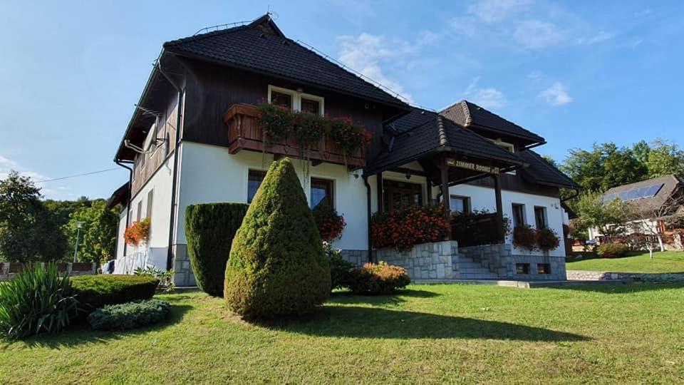 une maison avec un grand bush devant elle dans l'établissement Villa Knezevic, aux lacs de Plitvice