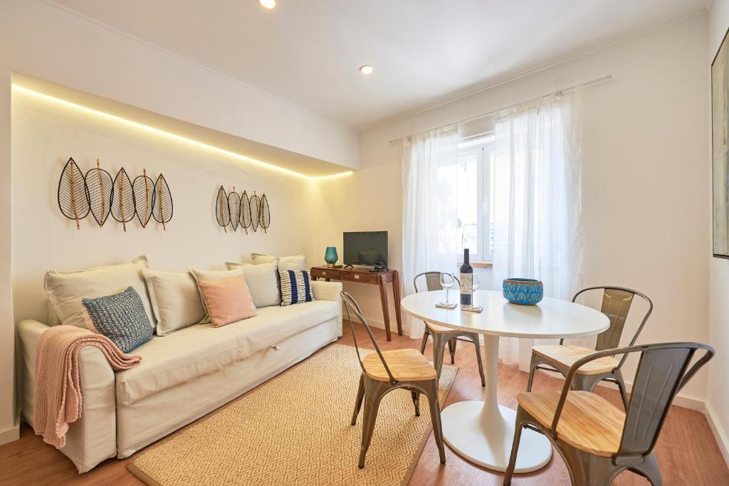 sala de estar con sofá y mesa en Belém Light Filled Apartment, By TimeCooler en Lisboa