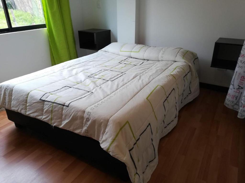 a large bed in a bedroom with at Apartamentos Paipa in Paipa