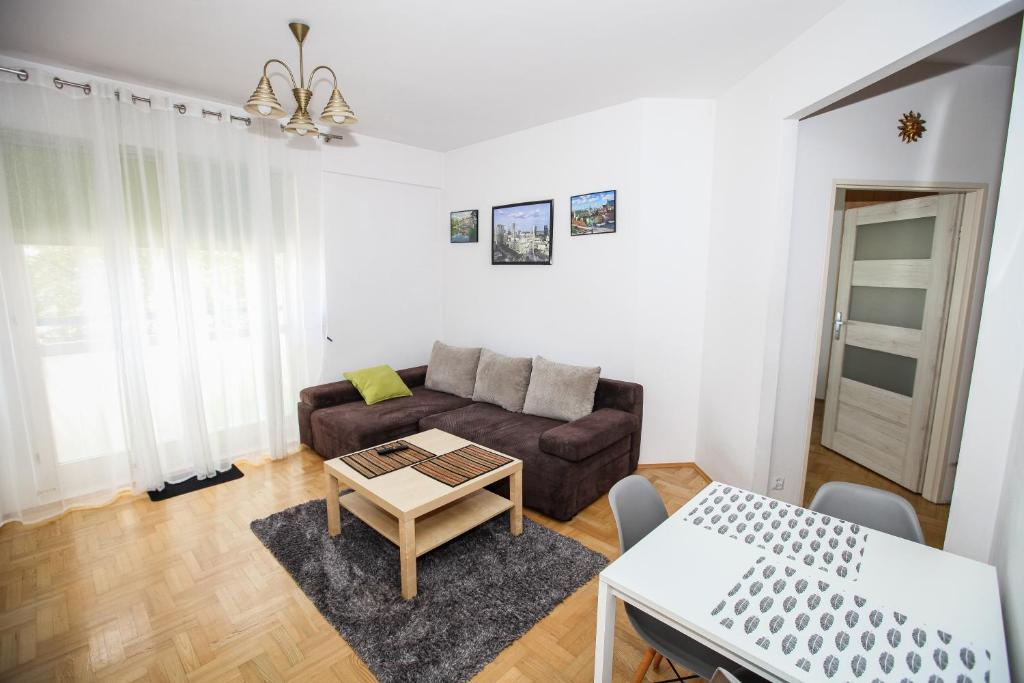 sala de estar con sofá y mesa en Green Kabaty Apartment, en Varsovia
