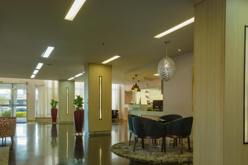 a lobby with a table and chairs and a kitchen at Lindóya Hotel in Catalão