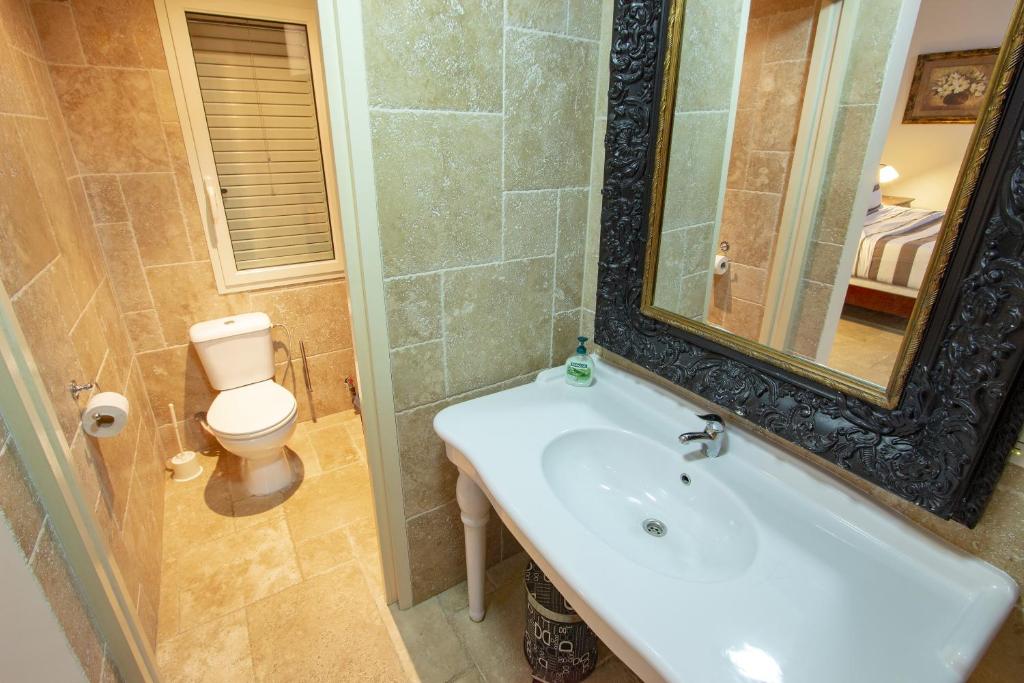 a bathroom with a sink and a toilet and a mirror at Aqua Breeze Apartment in Kralendijk