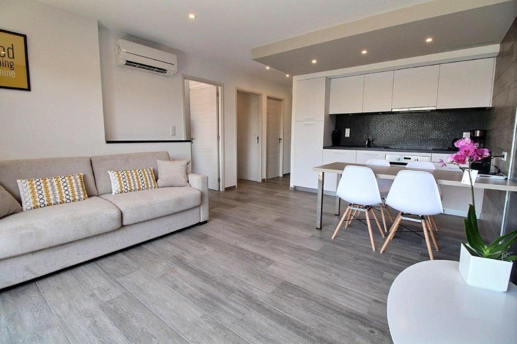 a living room with a couch and a table and chairs at Residence ACQUA LINDA Porticcio in Porticcio
