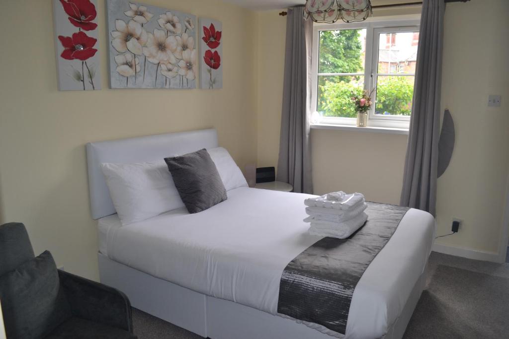 een slaapkamer met een wit bed en een raam bij Telford Claremont Mews Wellington in Telford