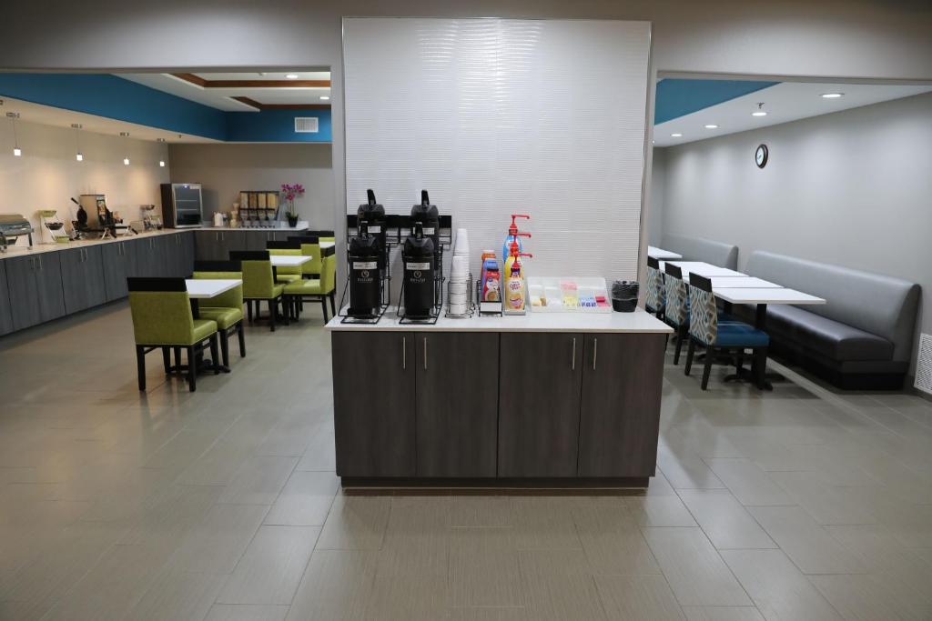a restaurant with a counter and tables and chairs at La Quinta by Wyndham Sulphur Springs in Sulphur Springs