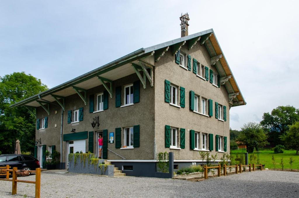 a large building with green shutters on it at Amodo Lodge in Saint-Paul-en-Chablais