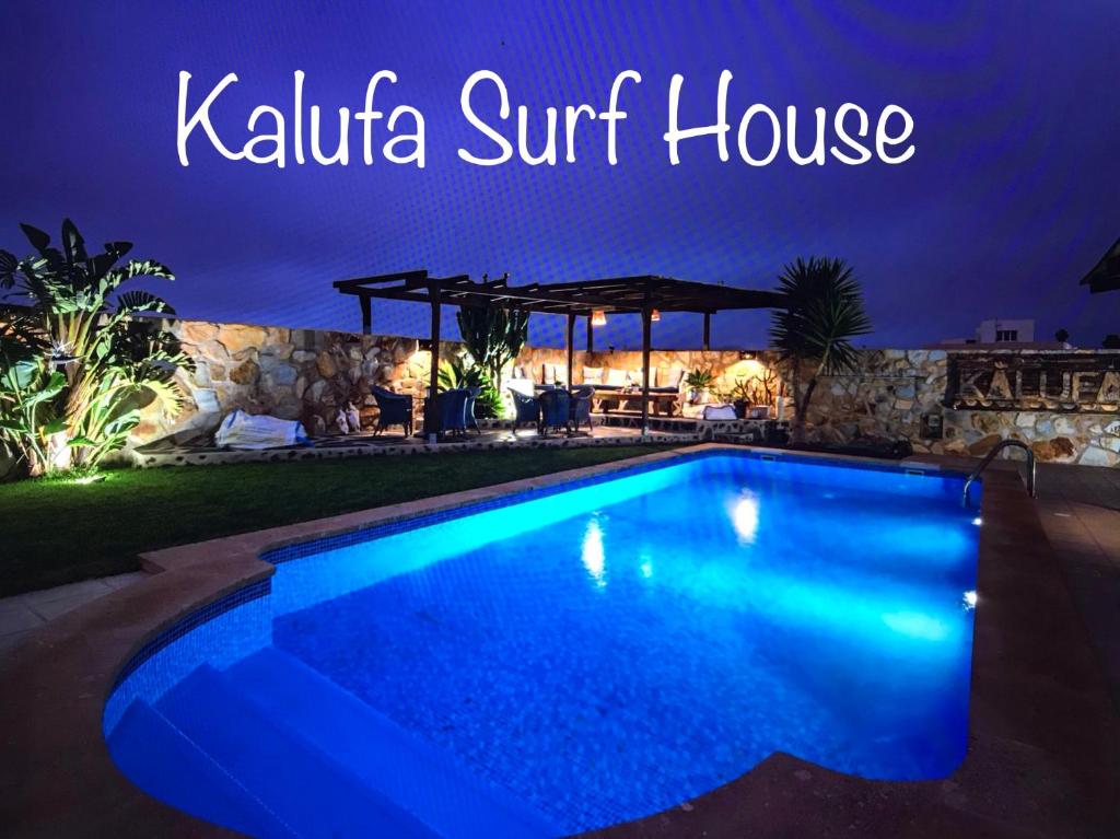 una piscina en una casa de la villa al atardecer por la noche en Kalufa Surf House en El Cuchillo