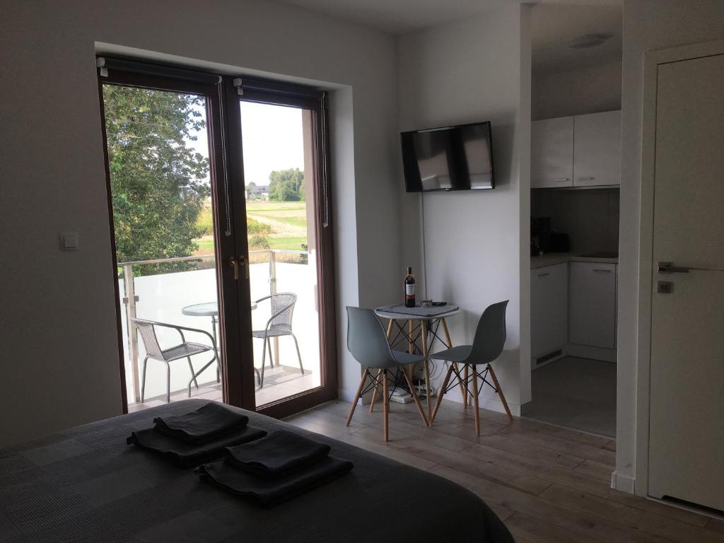 Cette chambre dispose d'un lit et d'un balcon avec une table et des chaises. dans l'établissement Studio Fibra Lungo, à Rybnik