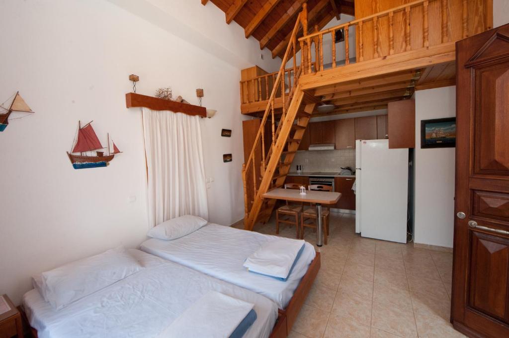 a small room with a bed and a staircase at Odyssia in Symi